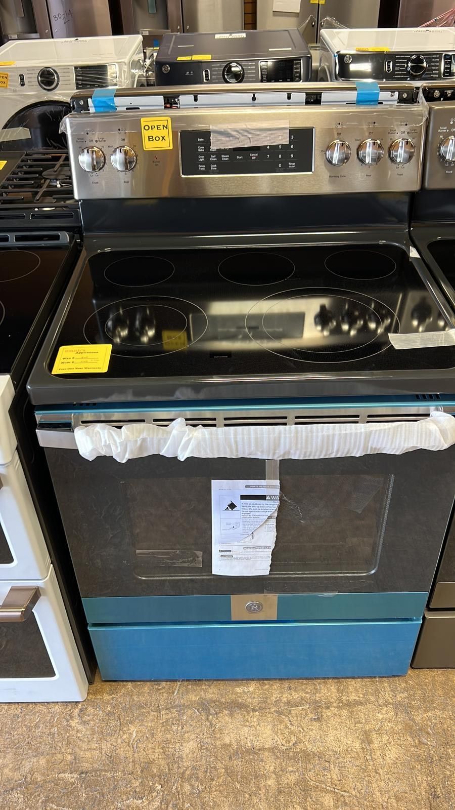 A stainless steel stove top oven is sitting on top of a wooden floor.