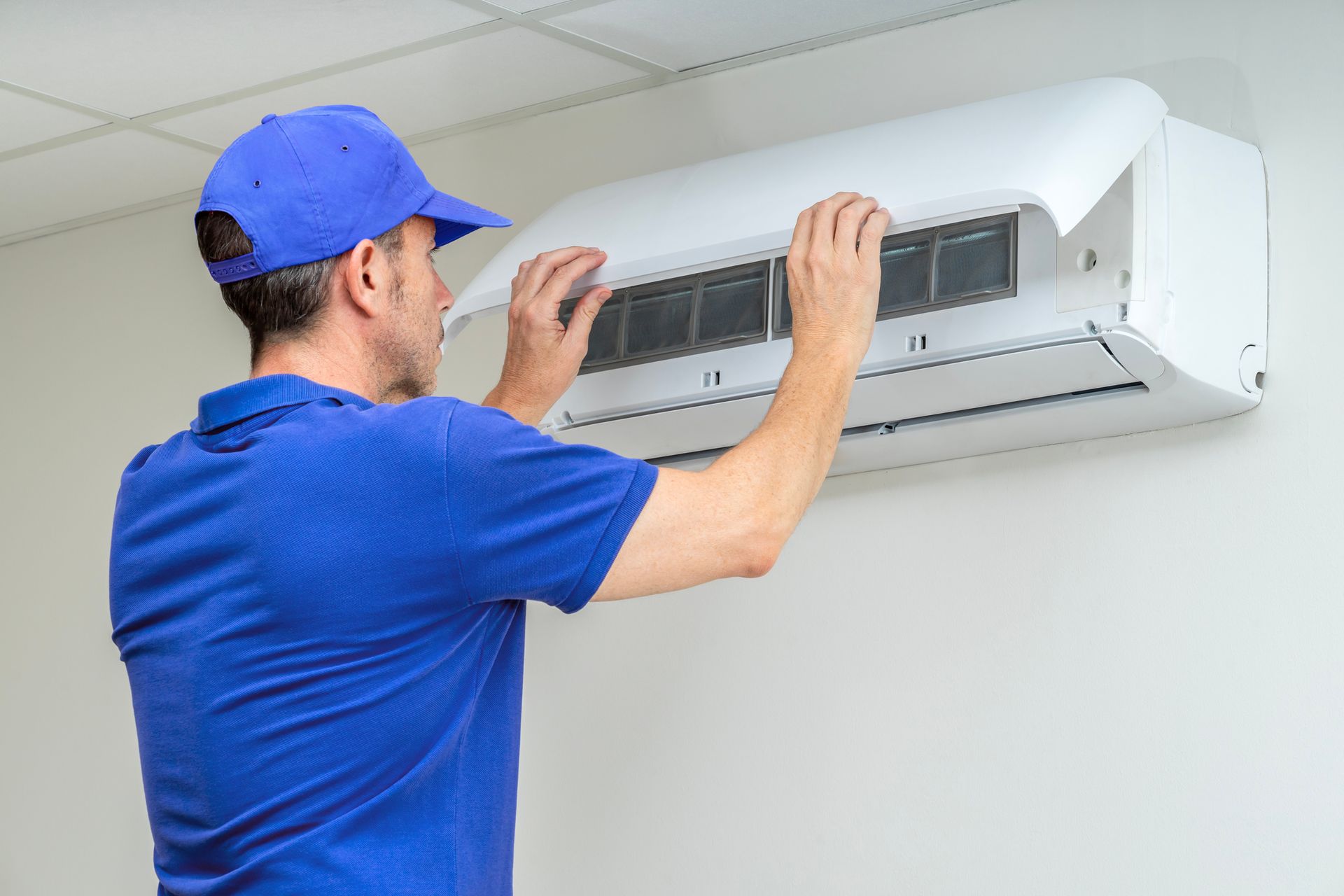 HVAC technician performing air conditioner maintenance inspection.