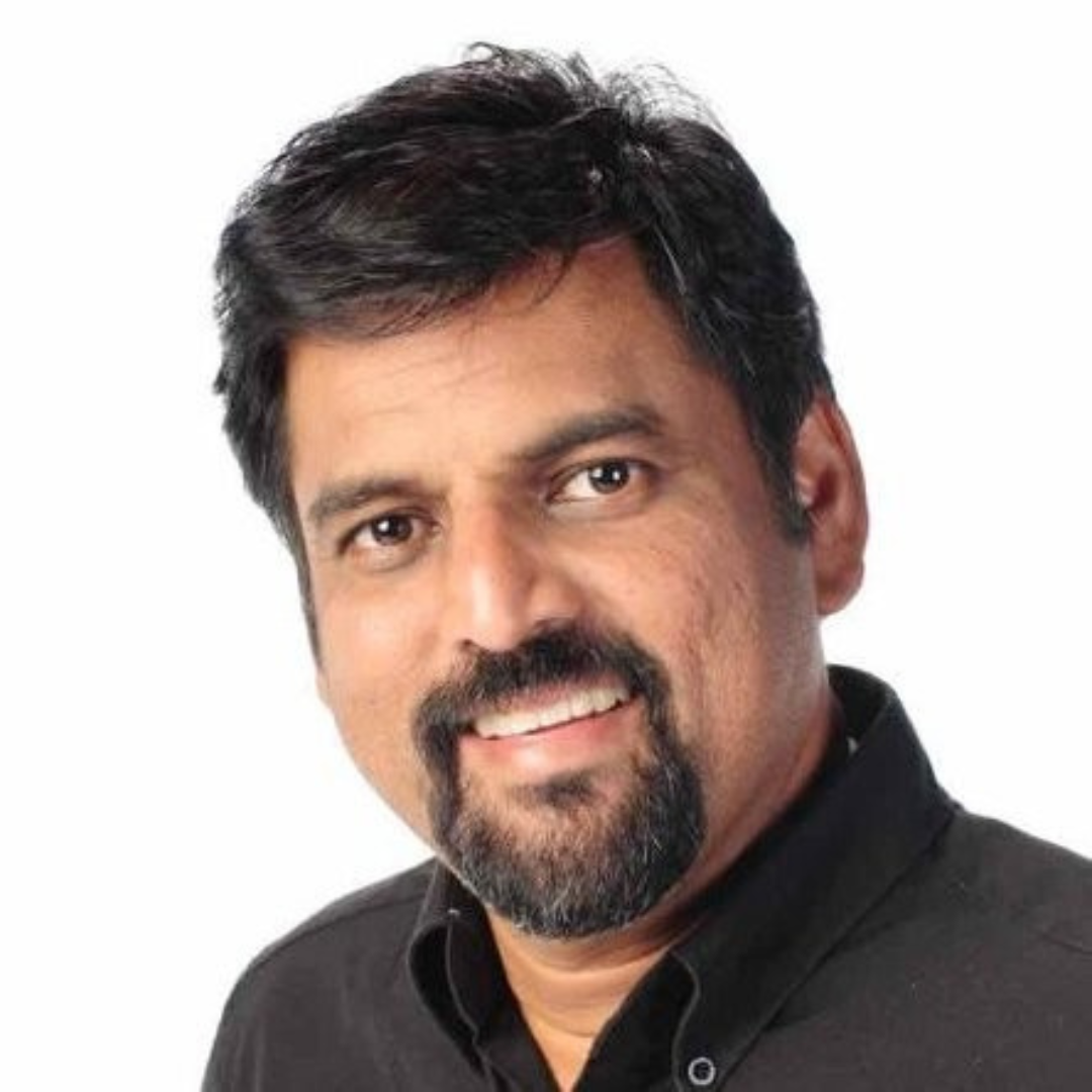 A man with a beard and mustache is smiling for the camera