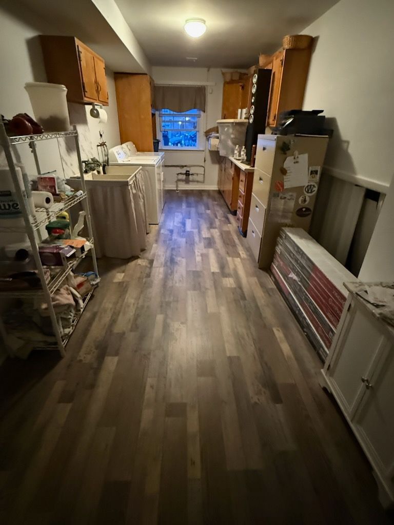 Narrow kitchen with wood cabinets, light flooring, a window, and shelves lining both sides.