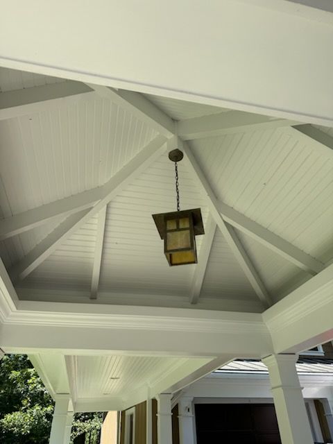 White gazebo ceiling with a hanging lantern light.
