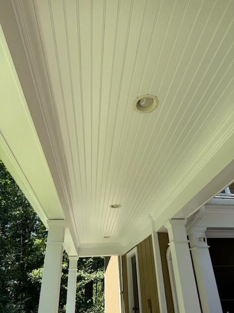 Covered porch ceiling with recessed lights and white beadboard panels