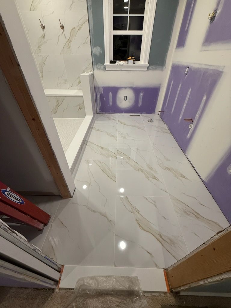 Small bathroom with glossy white marble tile floor and lavender walls, seen from the doorway.