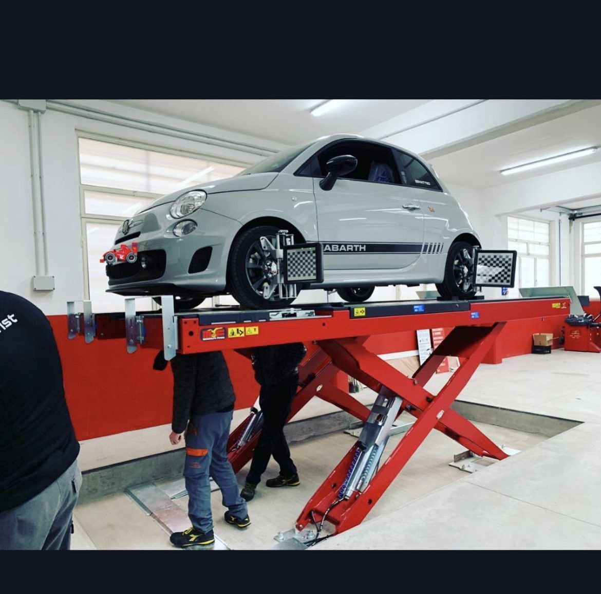 Un'auto su un ascensore con la scritta abarth sulla fiancata