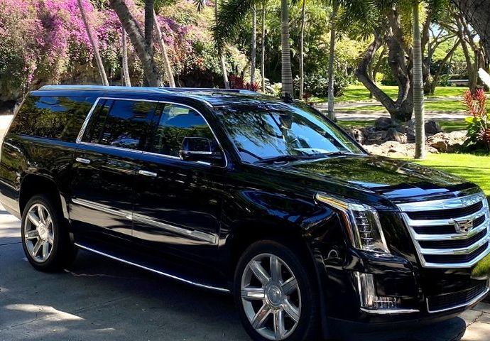 Black Cadillac Escalade SUV parked outdoors, shiny finish.