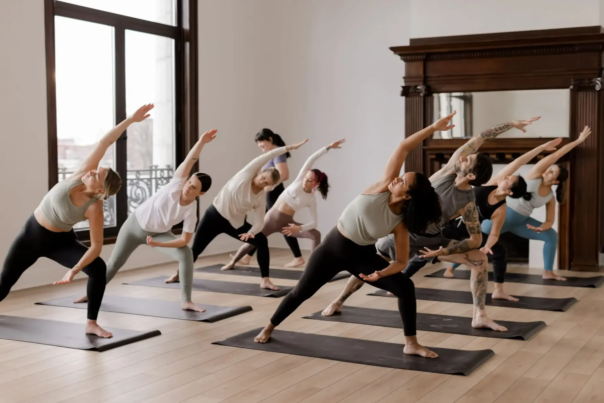 A group of people are doing yoga exercises in a room.