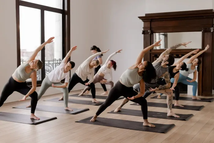 A group of people are doing yoga exercises in a room.