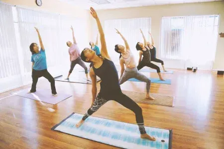 A group of women are practicing yoga in a gym.