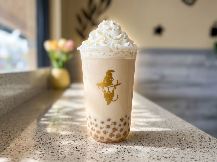 Iced caramel latte topped with whipped cream on a sunlit cafe table