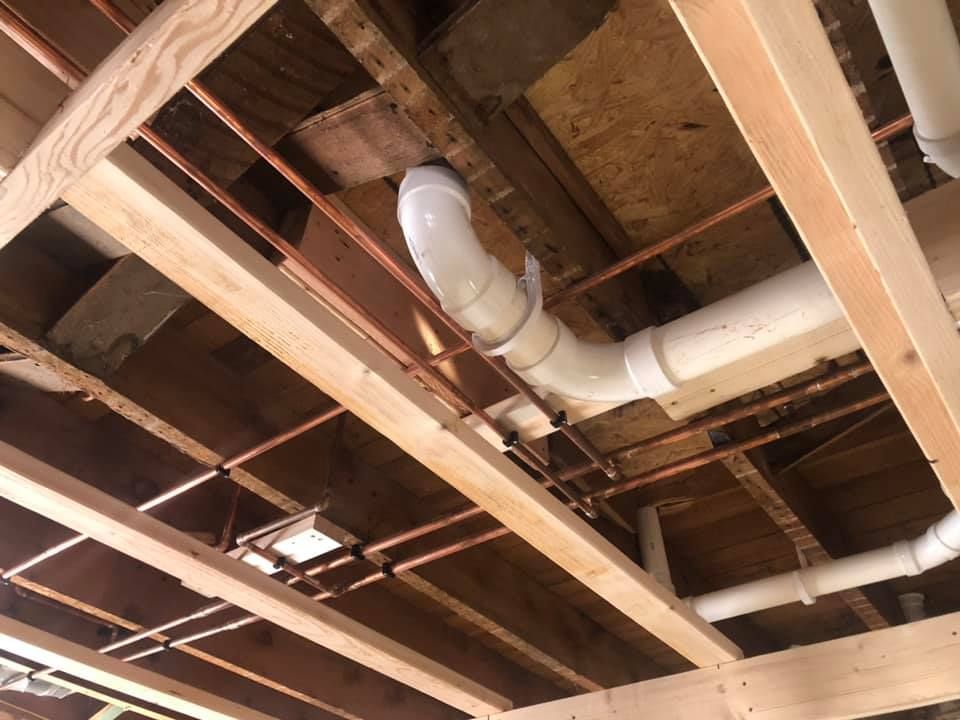 A pipe is hanging from the ceiling of a building under construction.