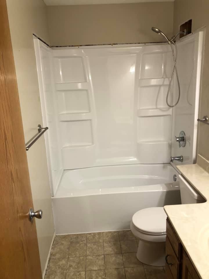 A bathroom with a tub , toilet and shower.