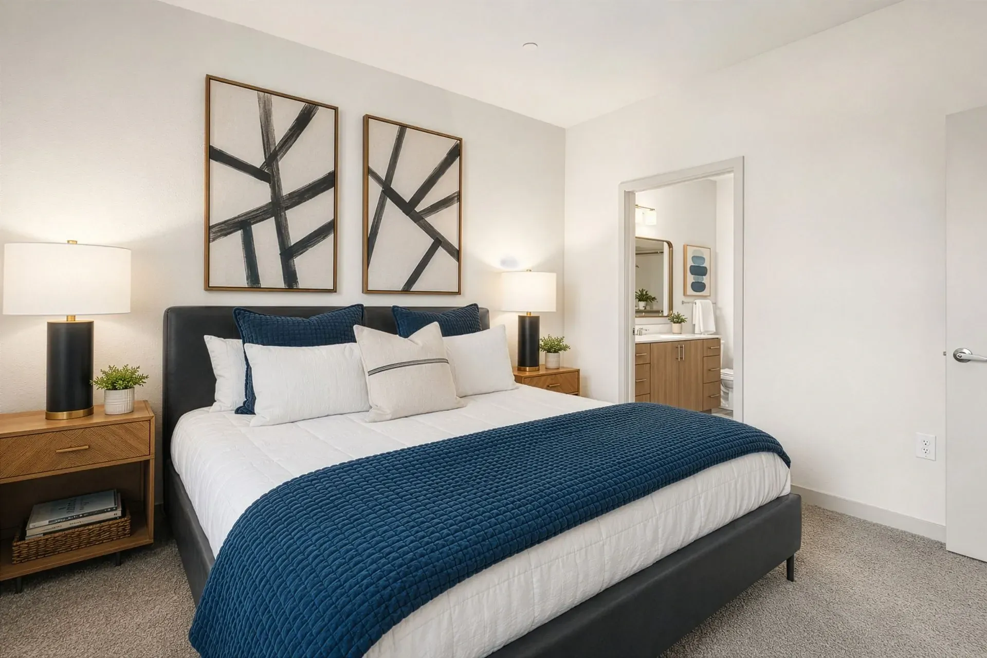 Luxurious bedroom with a king-size bed, plush bedding, and modern art at Parc Lofts in Tolleson, AZ.