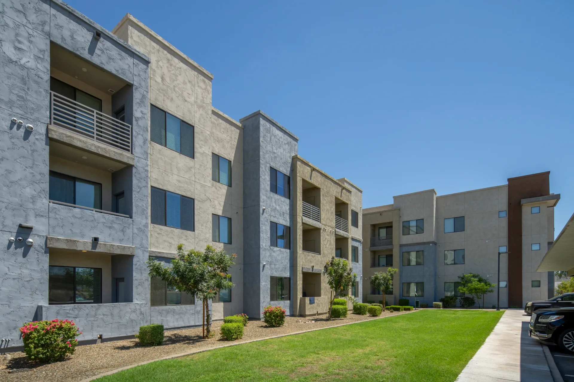 Exterior view of a modern apartment building with stucco facade and balconiesat Parc Lofts in Tolleson, AZ.