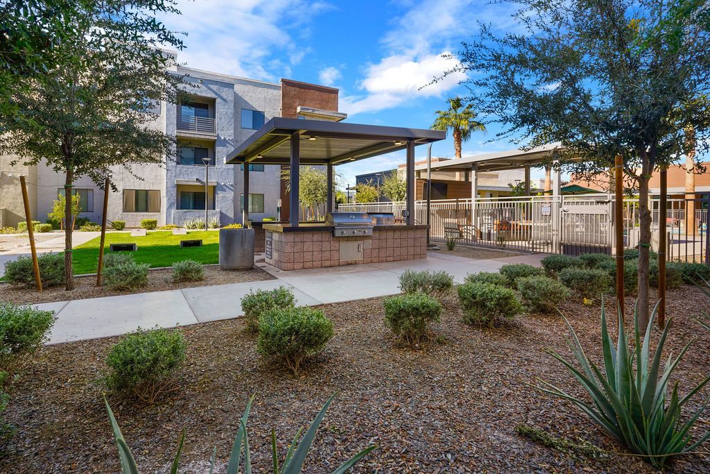 Parc Lofts communal grilling area with a shaded pavilion and desert landscaping.