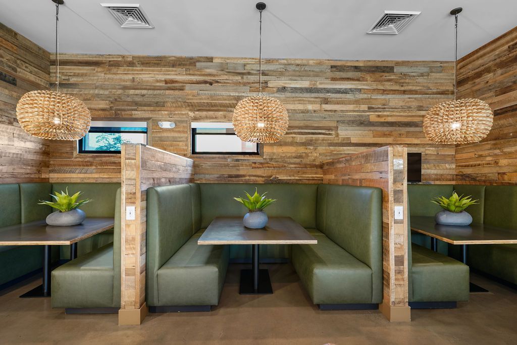 Parc Lofts seating in a wood-paneled dining area with green benches and pendant lights.