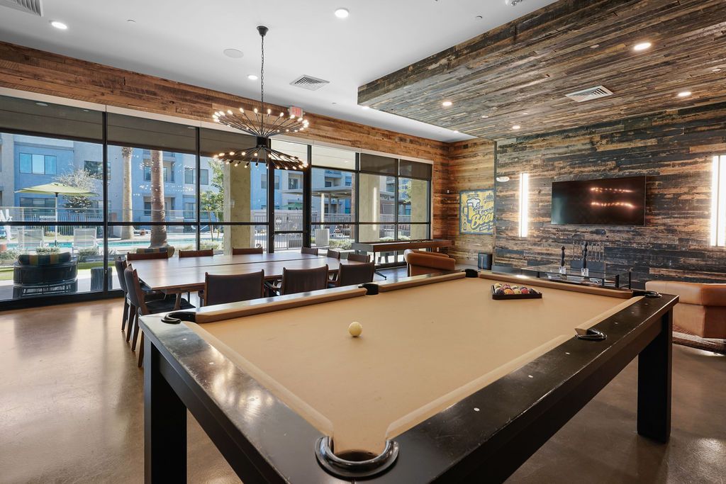 Parc Lofts recreation room with pool table, lounge seating, and large windows.