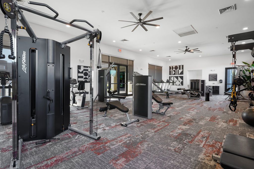 Parc Lofts Indoor apartment community gym with weight machines and cardio equipment.