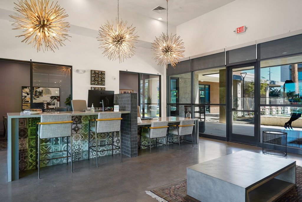 Parc Lofts apartment lobby with a reception desk, seating, and large glass doors to an outdoor area.
