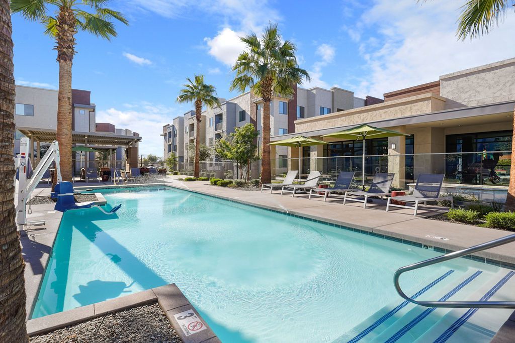 Parc Lofts pool at a modern apartment community with lounge chairs and palm trees.
