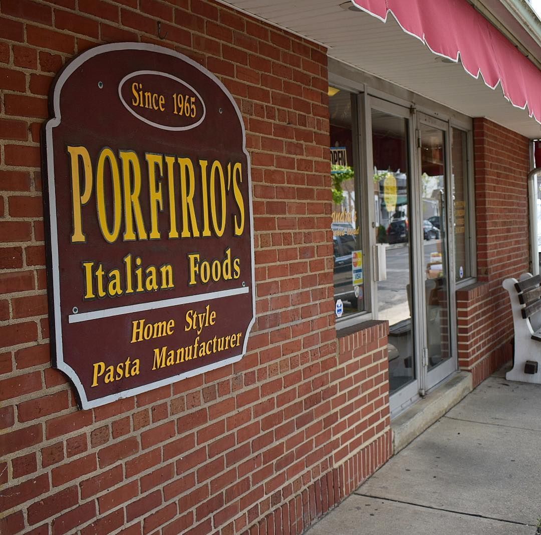 Porfirio’s Italian Foods storefront sign on a brick building with glass entrance door