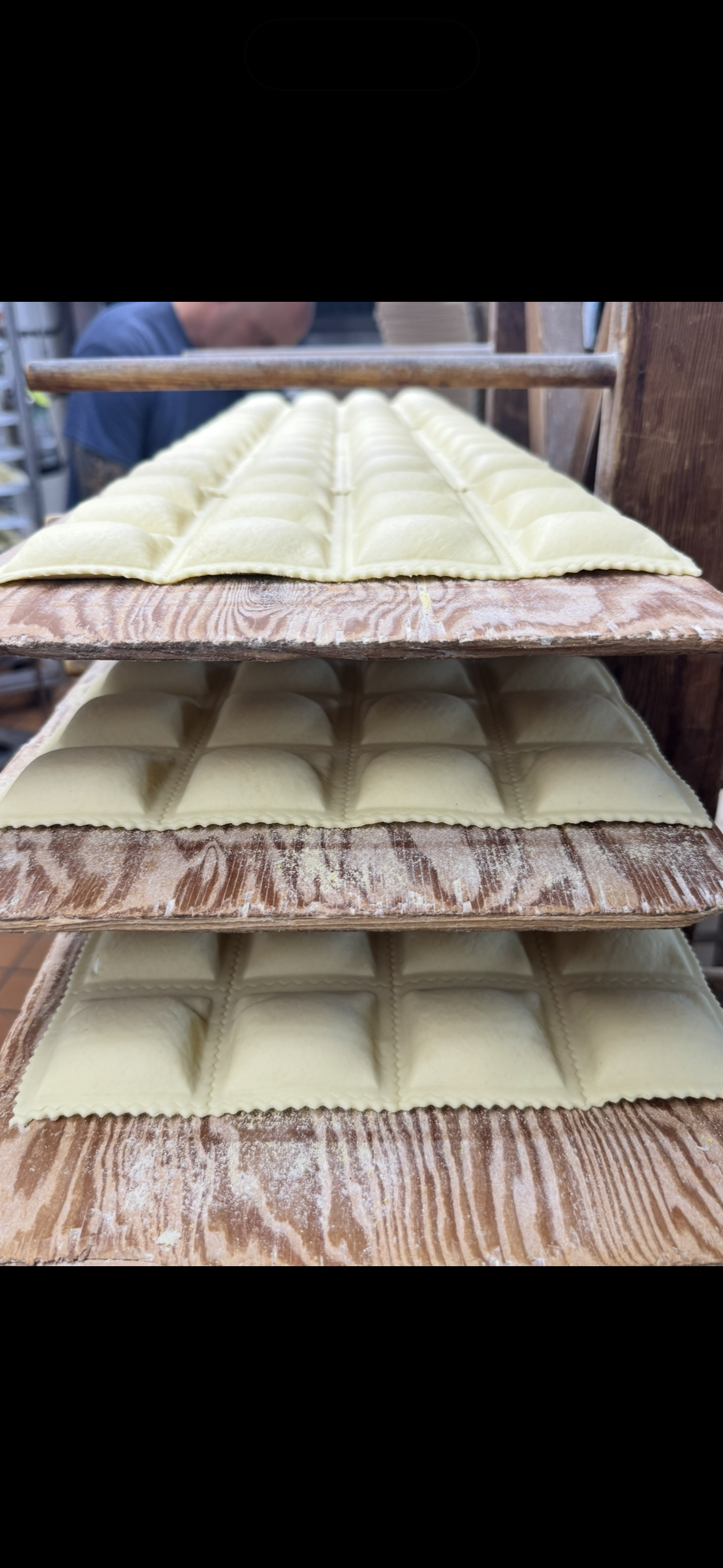 Stacked rows of pale green cream-filled pastries on trays
