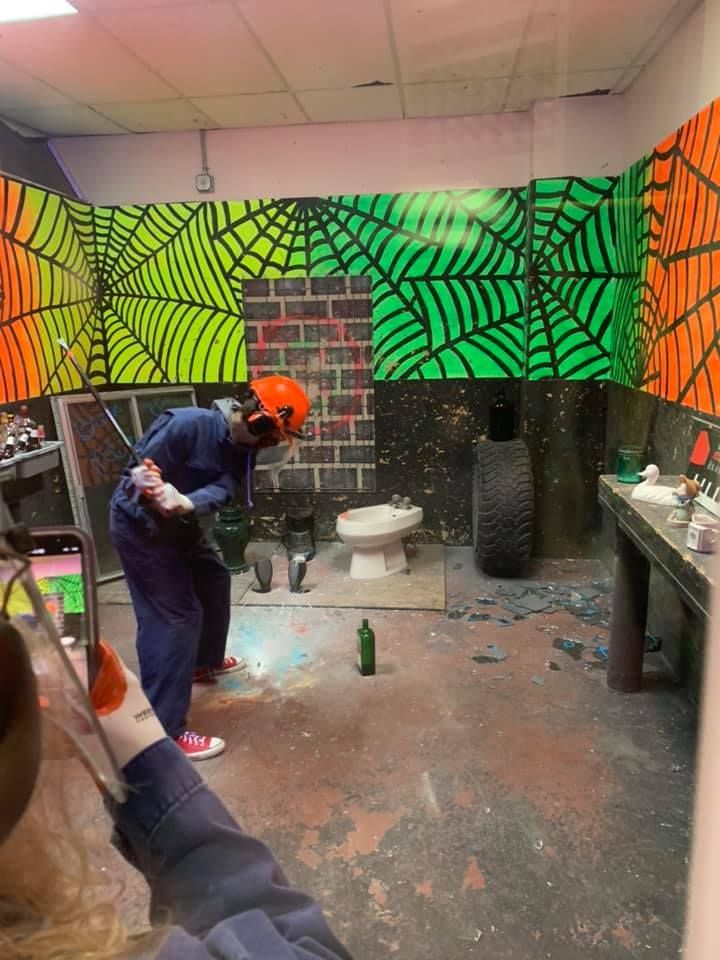A person is holding a hammer in a room with a toilet.