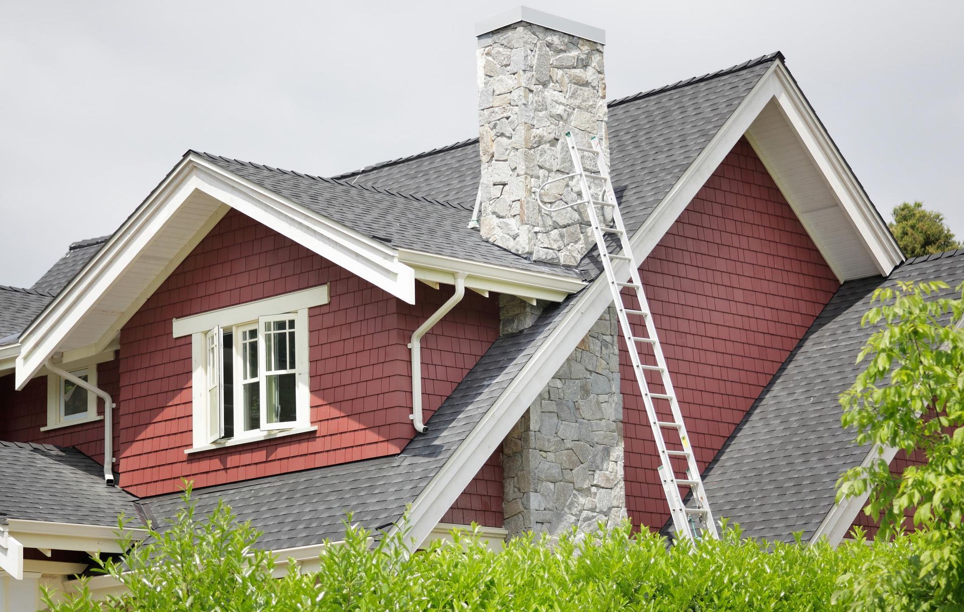 A house with a chimney and a ladder on the roof