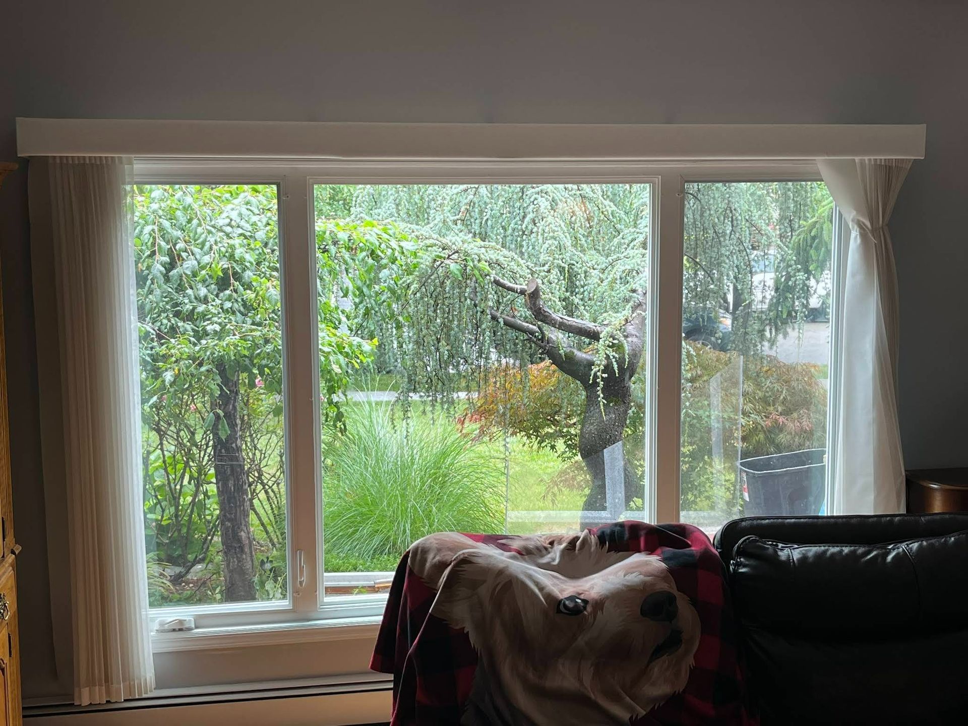 A living room with a large window and a couch.