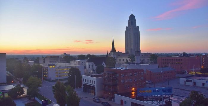 City skyline at dusk with the Nebraska State Capitol building prominent.
