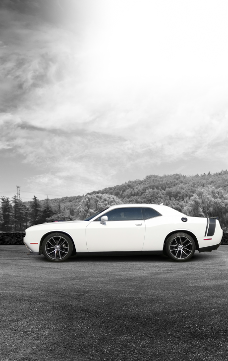 White sports car parked on a road with trees and mountains under a cloudy sky | New Pegasus Automotive