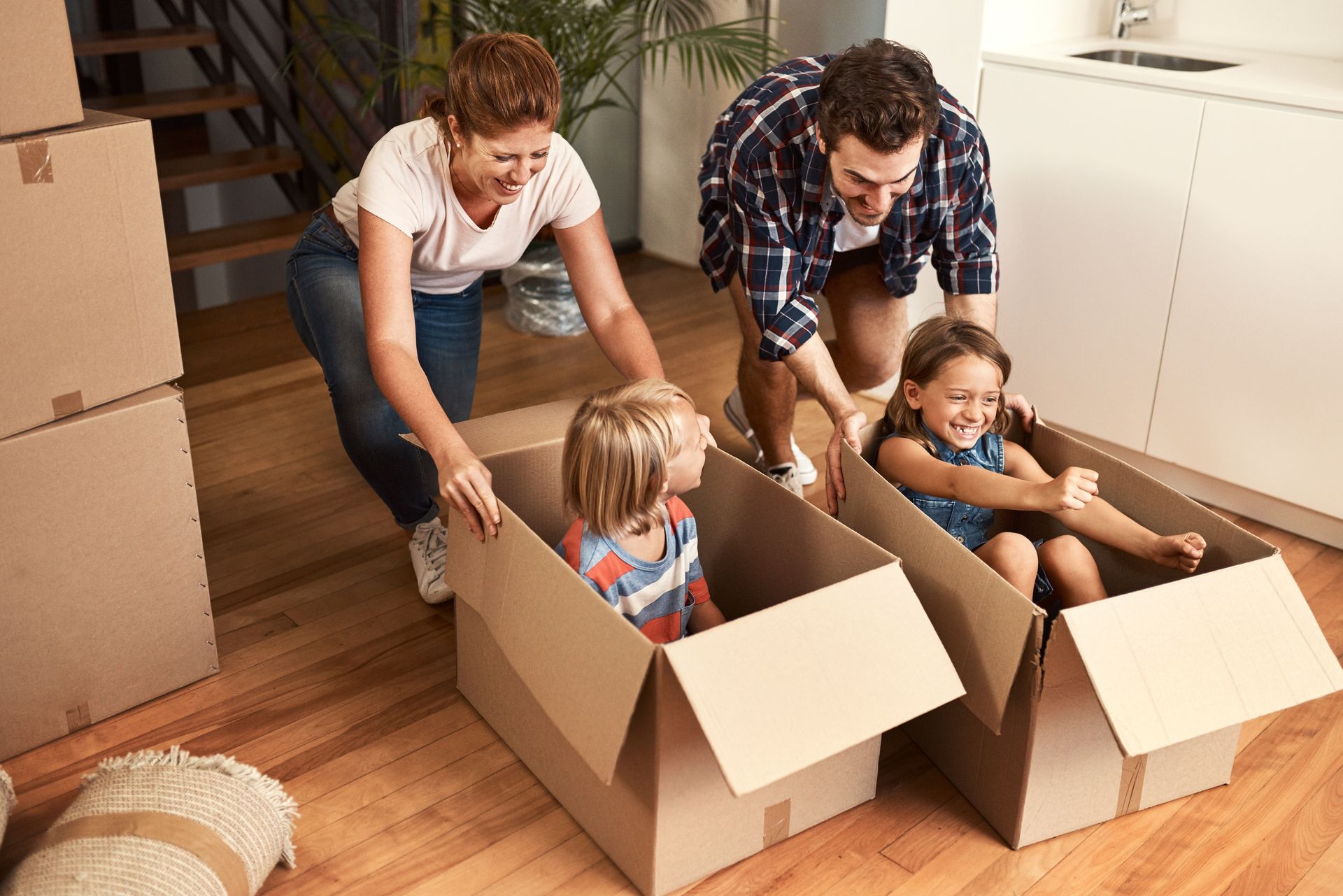 Family packing together in cardboard boxes during a move in a bright living room