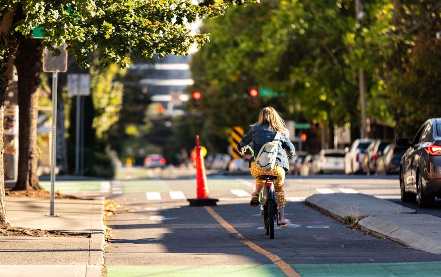 A woman is riding a bike down a city street