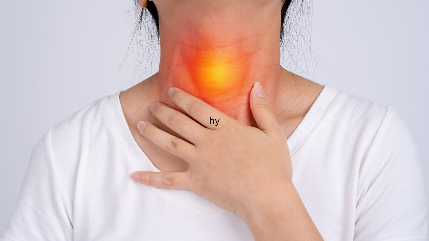 A woman reaches for her neck, where her thyroid is highlighted