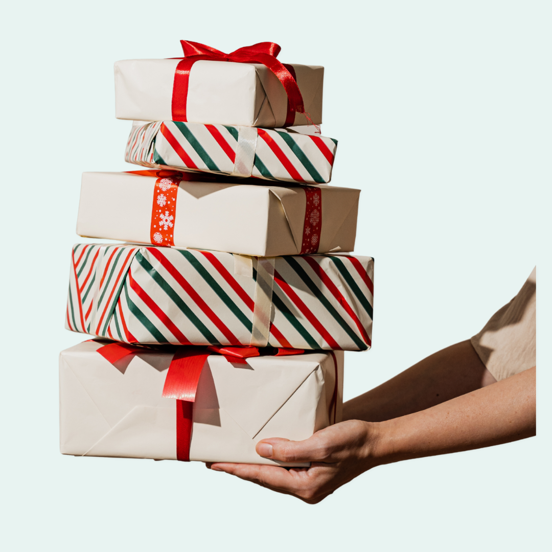 An outstretched arm holds a stack of wrapped holiday presents with bows