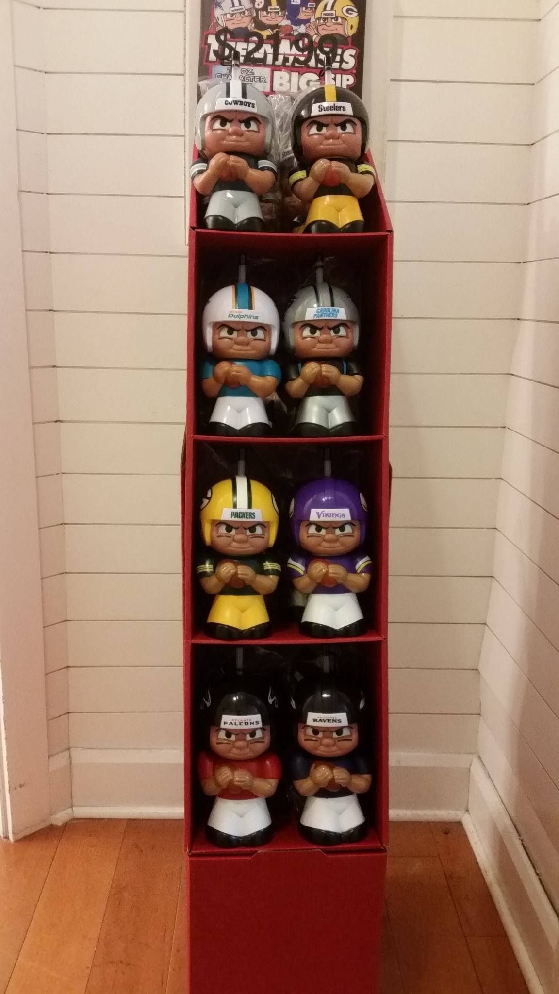 A red cardboard display holds eight miniature McDonald's NFL football player figurines in various team uniforms.