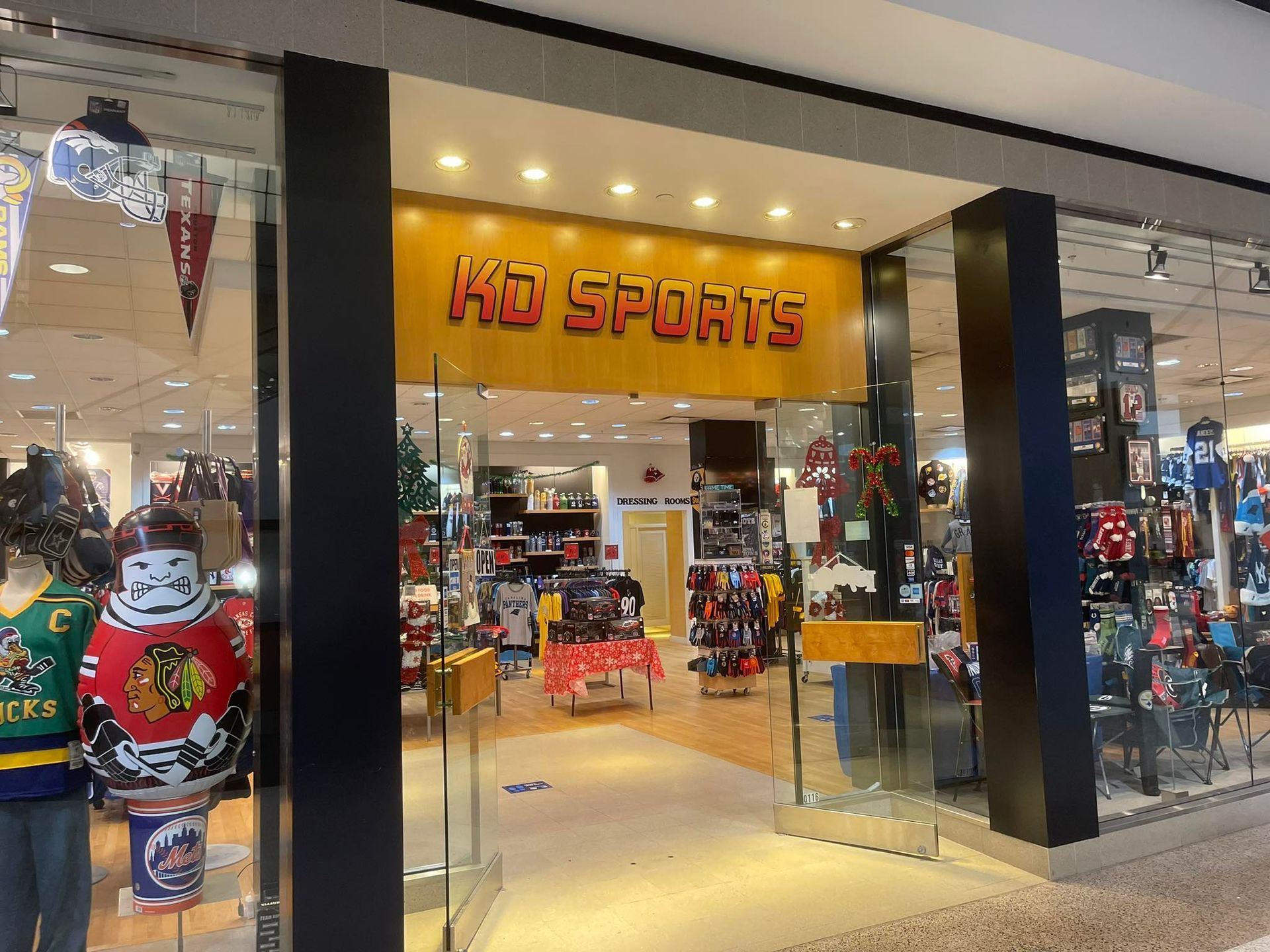 The storefront of KD Sports, a retail shop in a mall featuring sports jerseys and merchandise on display.