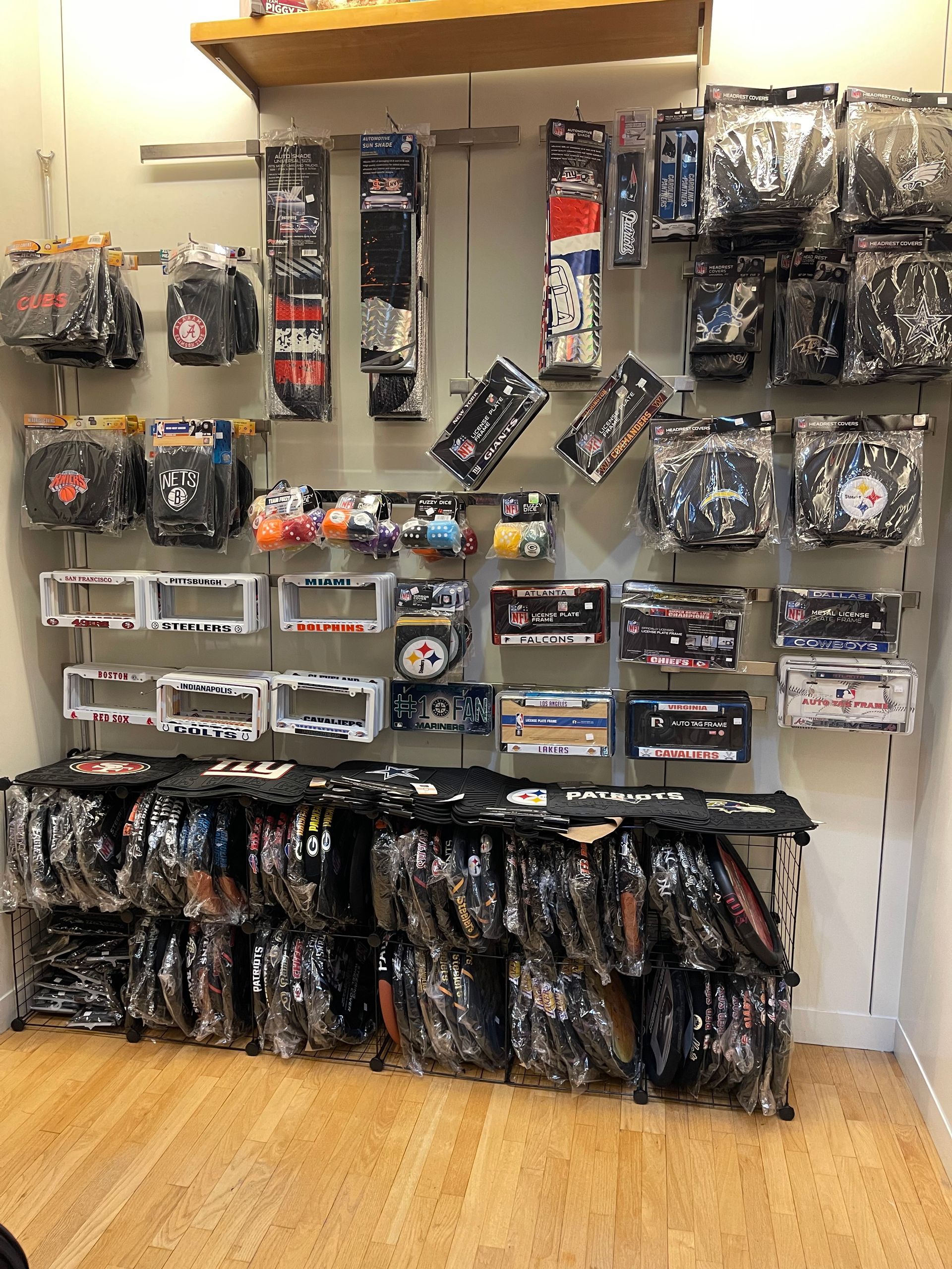 Retail display wall featuring packaged sports team merchandise, including hats, shirts, and accessories on shelves and racks.