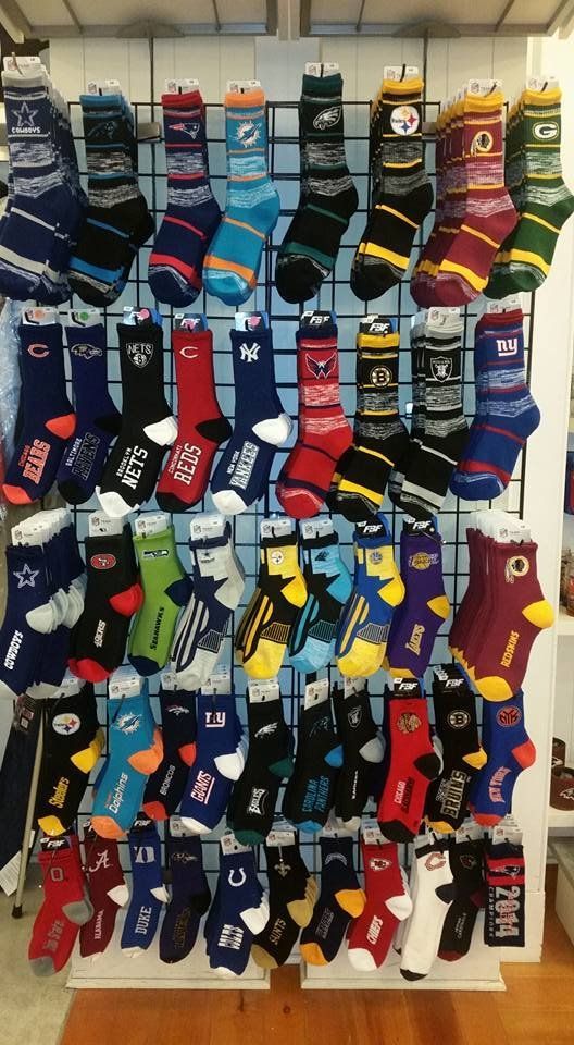 A display rack filled with rows of colorful, patterned NFL-themed crew socks for various teams, organized by rows.