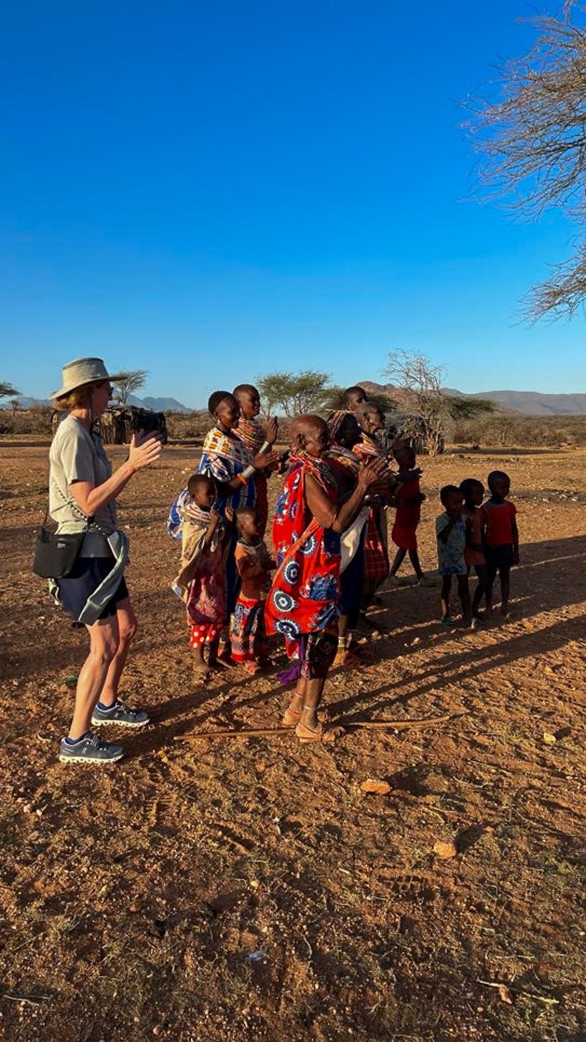 A woman is taking a picture of a group of children in a field.