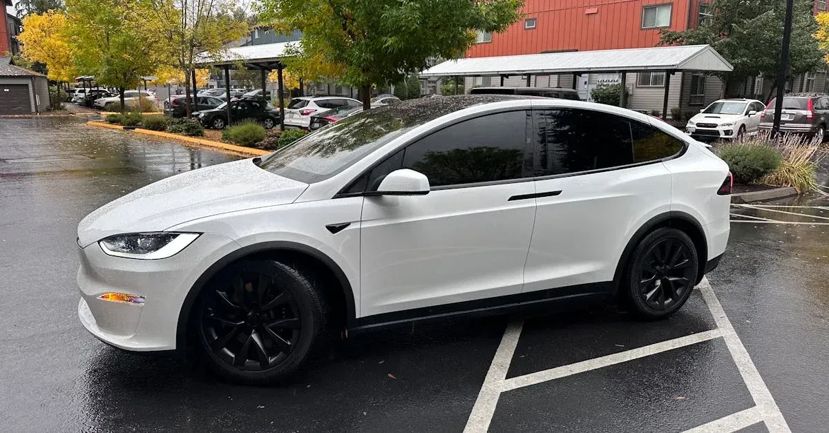 White electric SUV with dark tinted windows parked in lot, showcasing professional window.