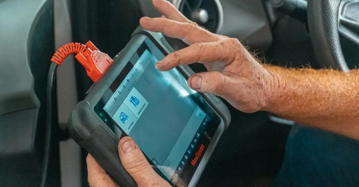 Mechanic using diagnostic tablet scanner in car for technical SEO automotive vehicle system testing and repair analysis.