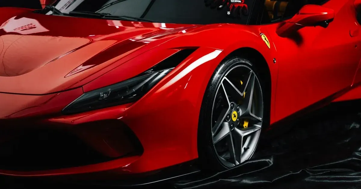 Glossy red Ferrari supercar showcasing ceramic coating shine and paint protection film automotive advertising ideas.