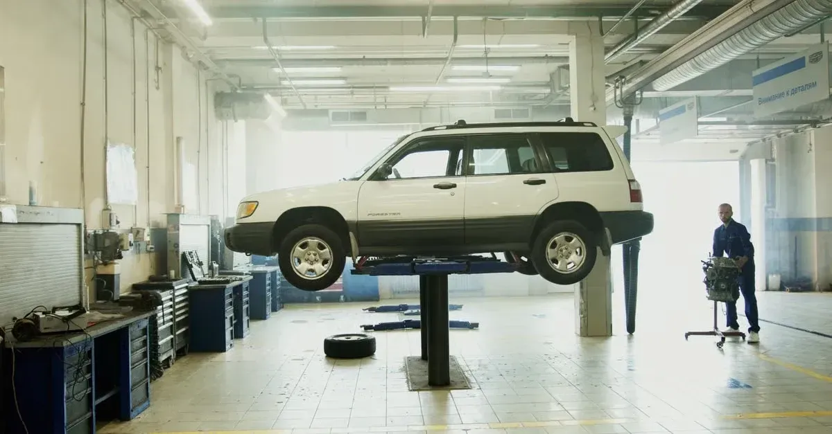 SUV elevated on auto service lift in professional shop, illustrating capacity. 