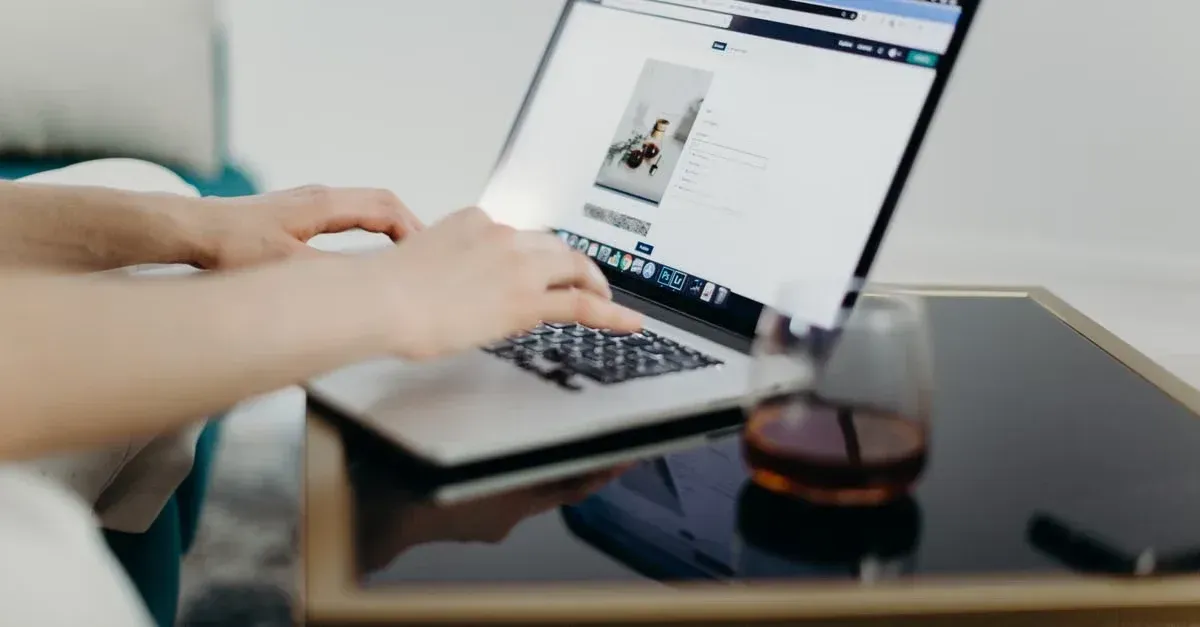 Person using laptop to browse booking platform, helping get more detailing clients online.