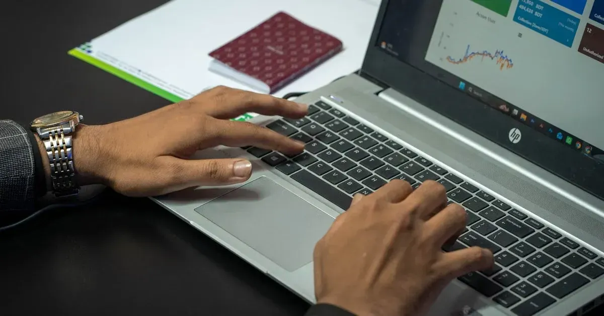 Person typing on laptop analyzing automotive SEO dashboard with charts and data on screen.