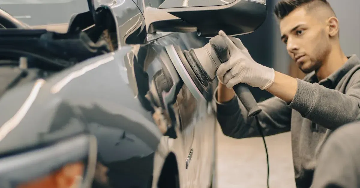 Worker polishing a black car’s side mirror in an auto detailing shop