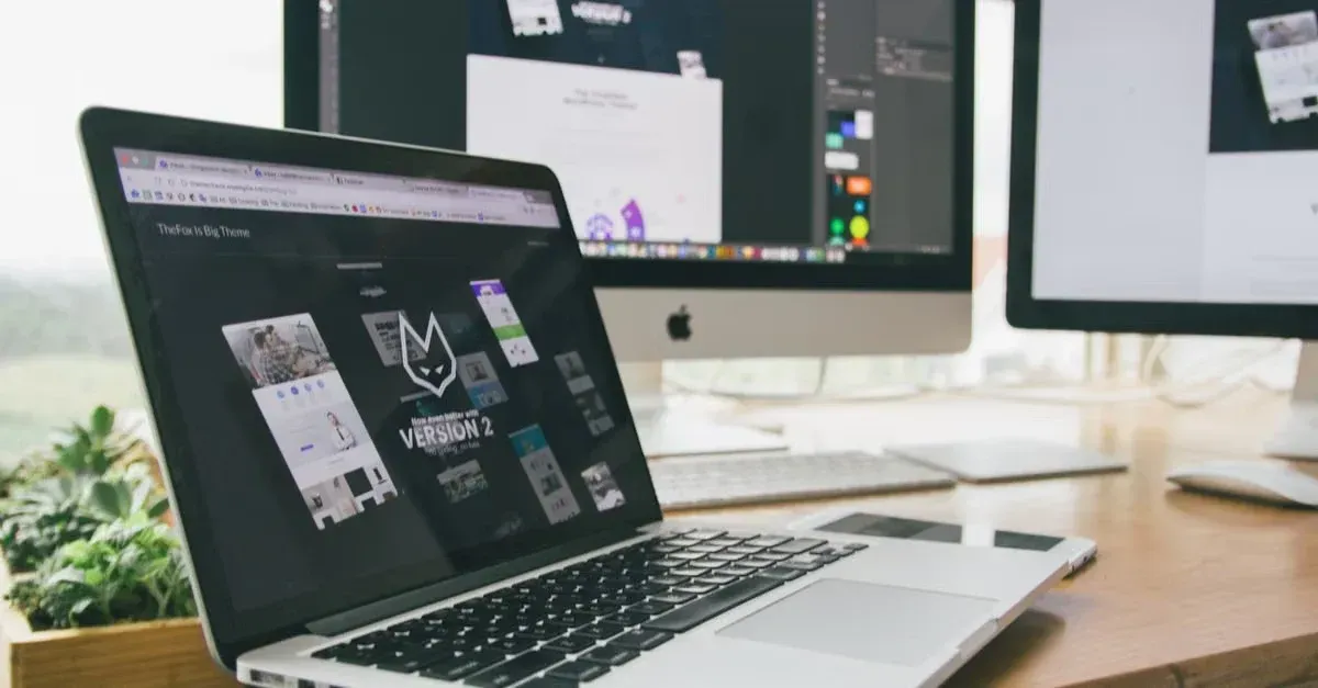 Designer workspace with laptop and monitors displaying website provider tint PPF design mockups and layout templates.