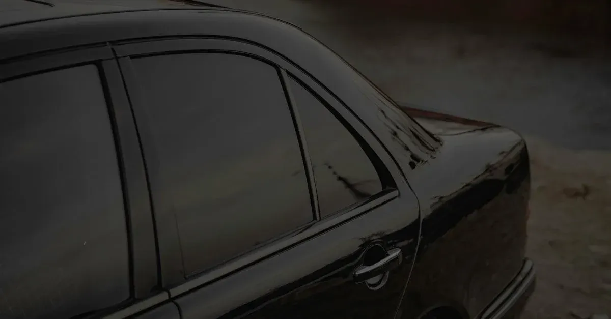 Black sedan with professional window tinting applied to side windows, showcasing tinted car windows installation quality.
