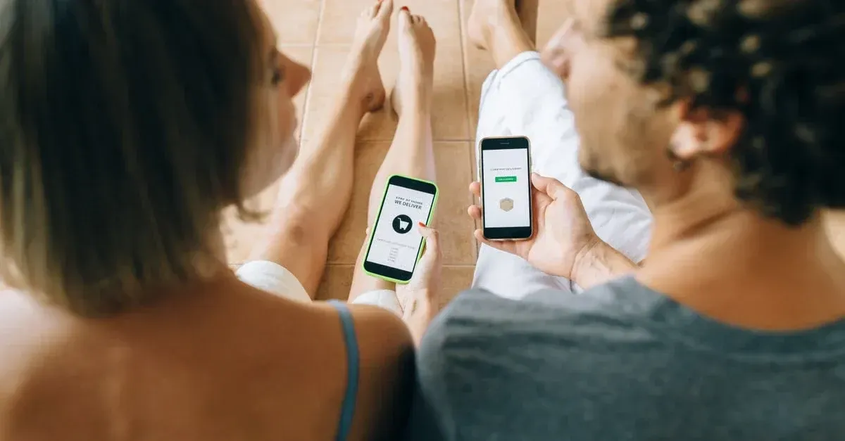 Two people holding phones displaying tint and PPF website provider services on screens.