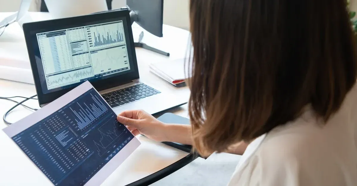 Woman analyzing spreadsheets and data charts on tablet to grow tint business profitably and efficiently.